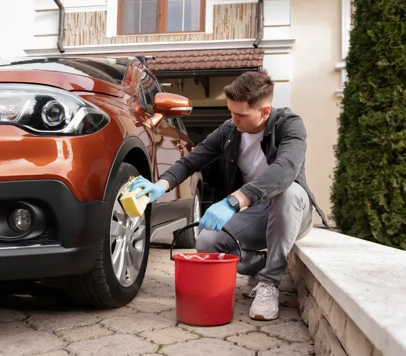Lavage auto à domicile Téteghem-Coudekerque-Village : professionnel intervenant sur un véhicule